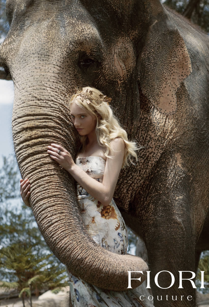 Girl with a golden FIORI crown holds an elephant
